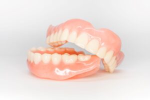Full set of dentures stacked asymmetrically on a white background