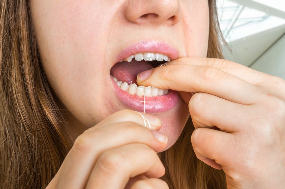 A woman flossing her teeth